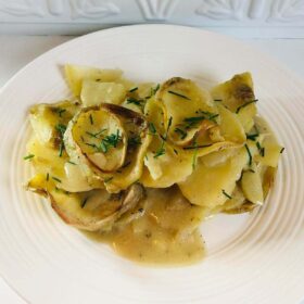 Scalloped potatoes made with almond milk on a white plate.