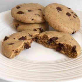 A cookie broken in half with three more cookies behind it.