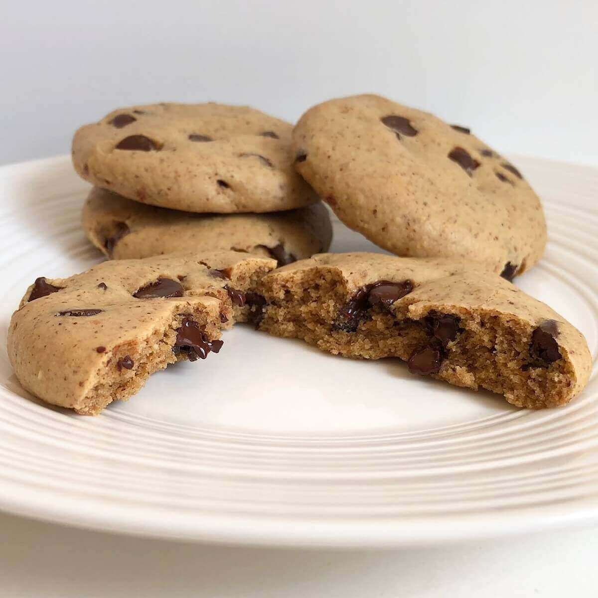 Four chickpea flour cookies on a white plate.