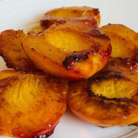 Cooked peaches piled on a plate.