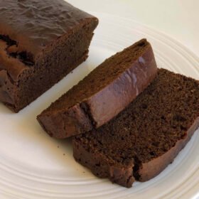 Gluten free gingerbread cake with two slices cut on a plate.