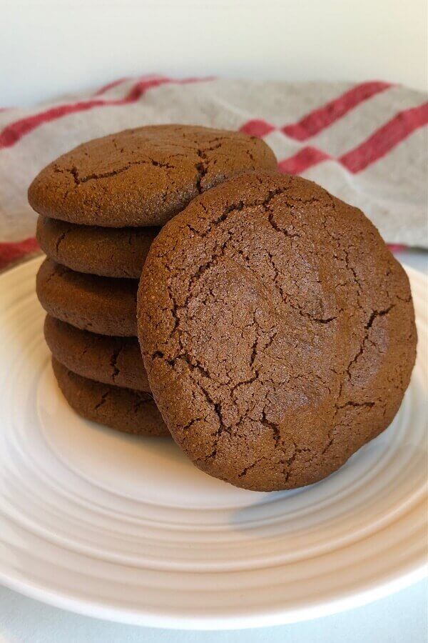 Cookies on a plate in front of a linen dish towel.