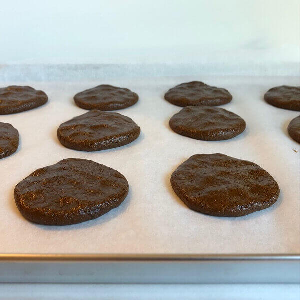 Raw gingerbread cookies on a sheet pan.