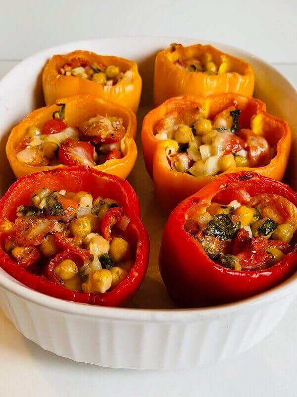 Cooked stuffed peppers in a white dish.