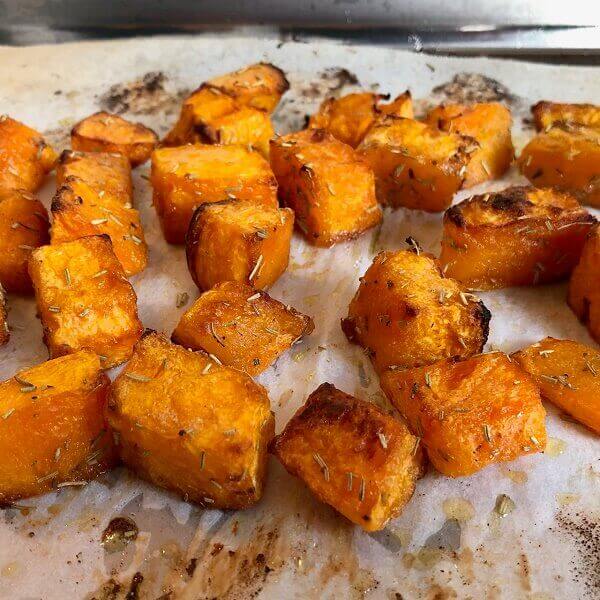 Baked squash on a sheet pan lined with parchment paper.