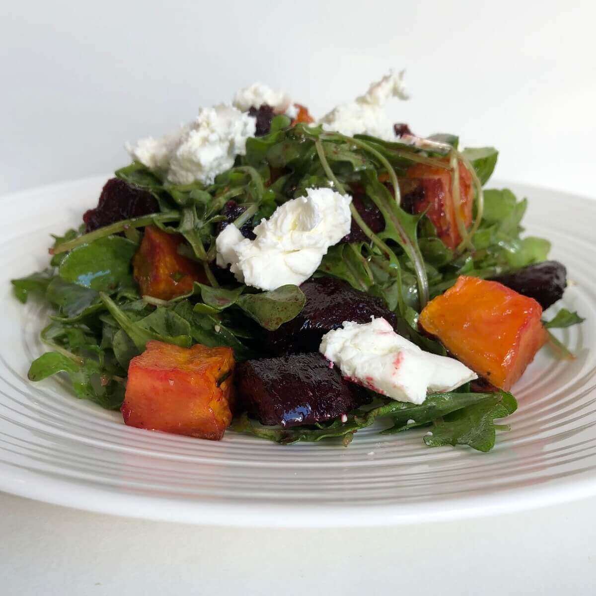 Beetroot and sweet potato salad piled on a white plate.