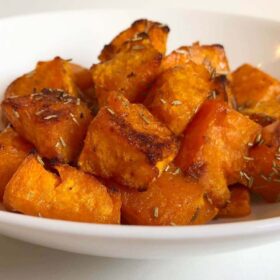 Baked butternut squash in a white bowl.