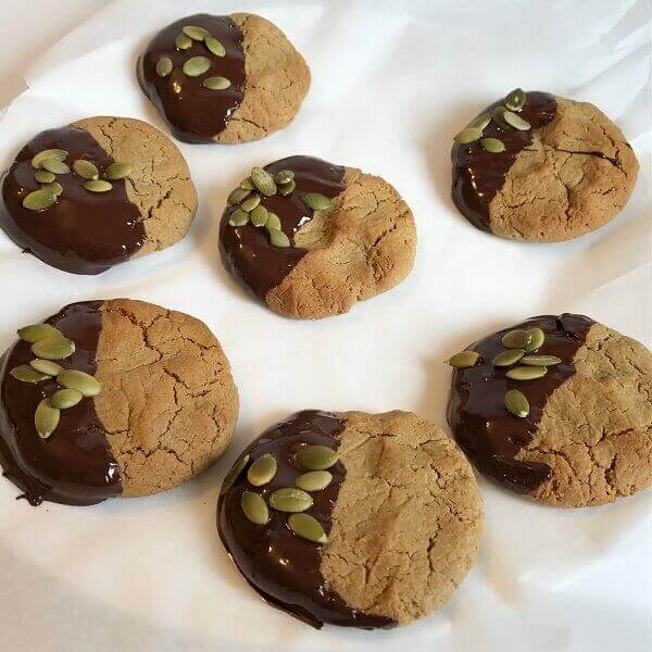 Chocolate dipped cookies drying on parchment paper.