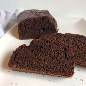 A loaf of flourless bread with two slices cut.
