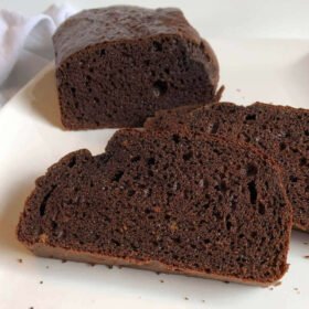 A loaf of bread behind two thick slices.