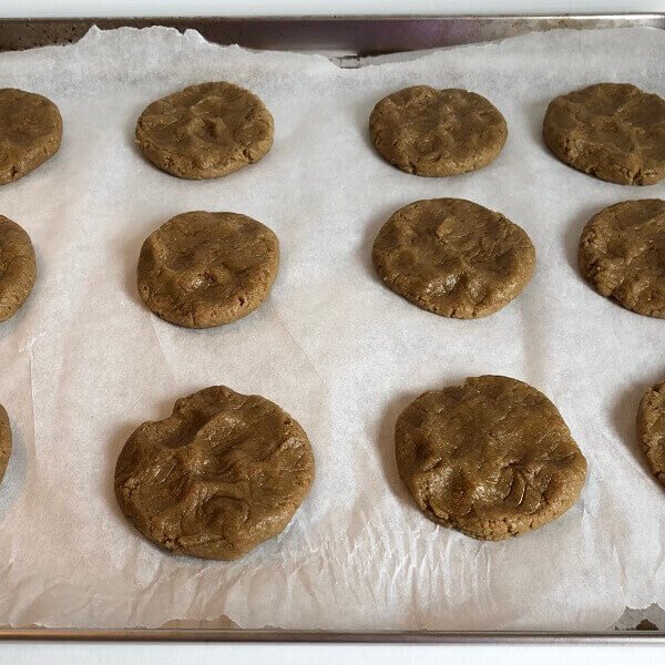 Raw cookies on a parchment paper lined sheet pan.