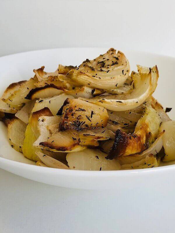 Cooked onions piled in a white bowl.