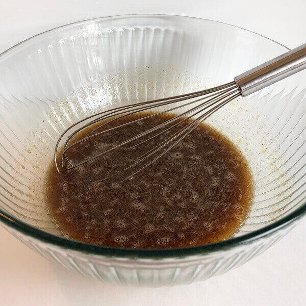 Wet ingredients in a mixing bowl with a whisk.