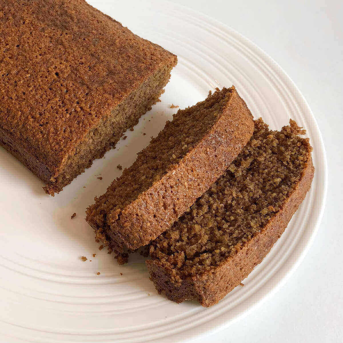 Two thick slices of cake next to the rest of the loaf.