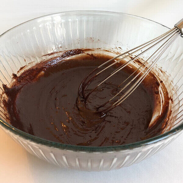 Brownie batter in a glass mixing bowl.