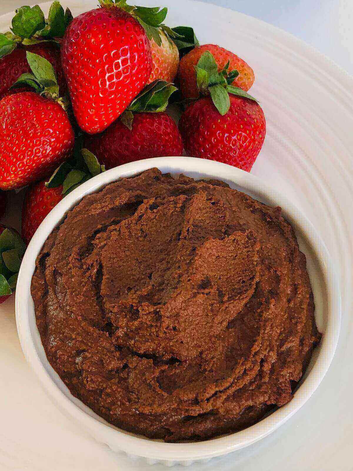 Dessert hummus in a bowl next to some strawberries.