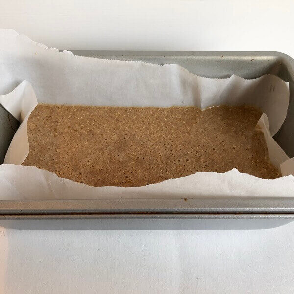 Cake batter in a parchment paper lined pan.