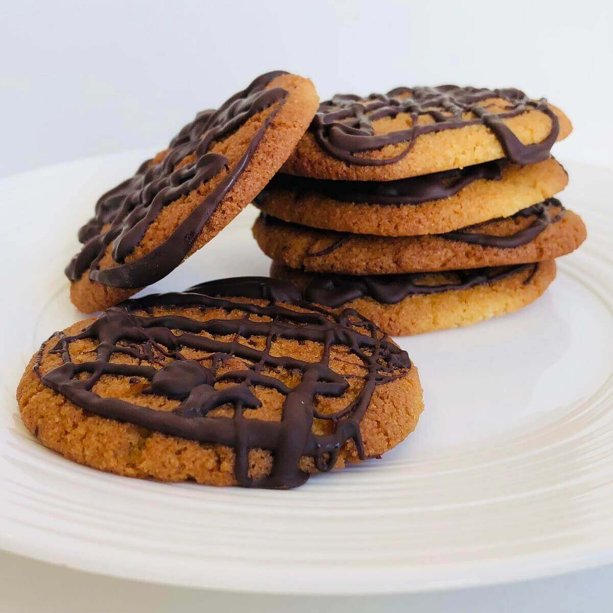 Six cookies arranged on a white plate.