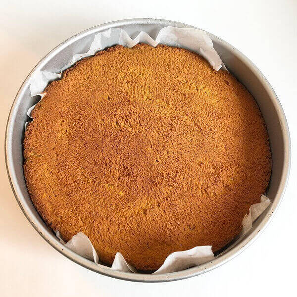 Cake in a baking pan lined with parchment paper.