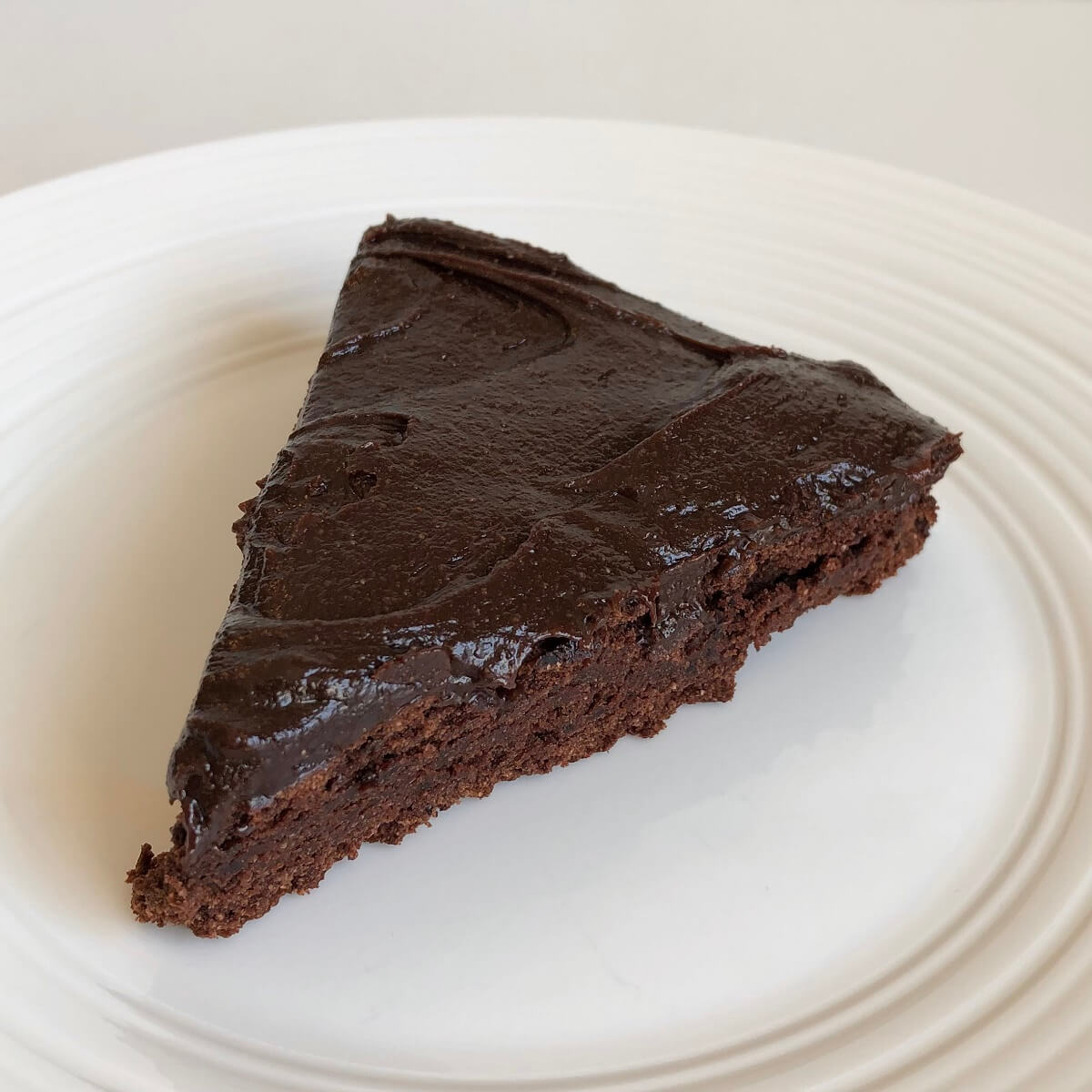 A slice of frosted chocolate black bean cake.