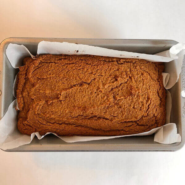 Carrot cake in a parchment paper lined loaf pan.
