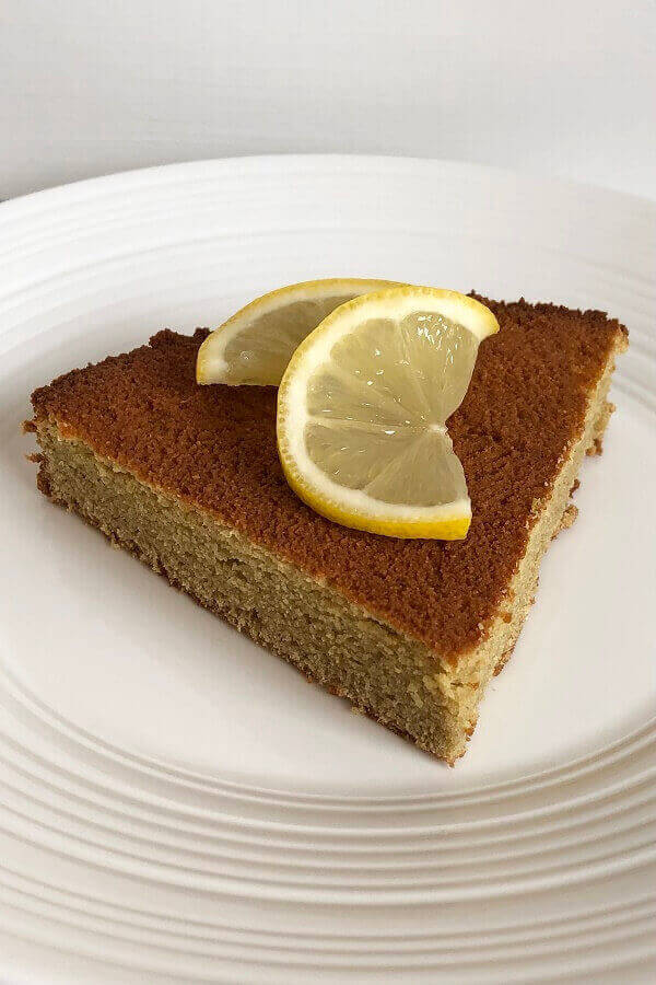 A slice of lemon cake on a white plate.