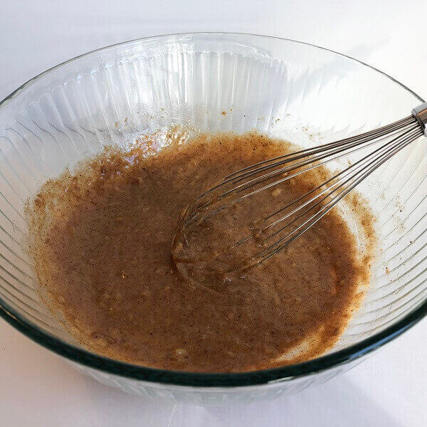 Ingredients in a bowl with a whisk.