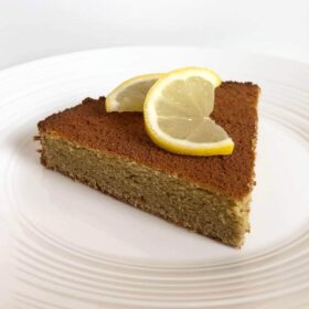 A slice of cake garnished with a lemon twist.