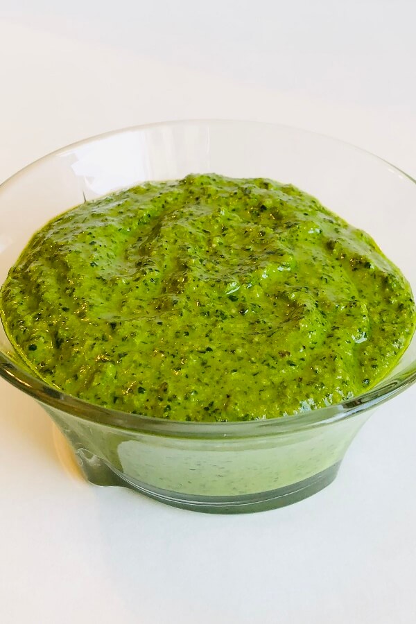 A glass bowl filled with pesto.