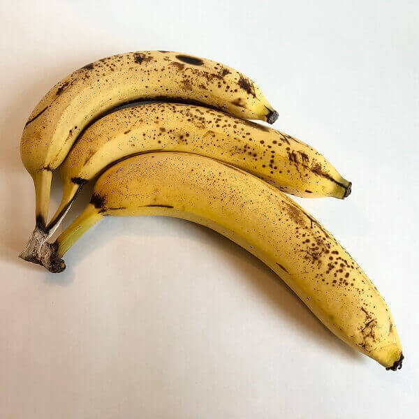 Three ripe bananas against a white background.