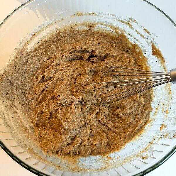 Banana bread batter in a large glass mixing bowl.