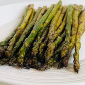 Roasted asparagus piled on a plate.