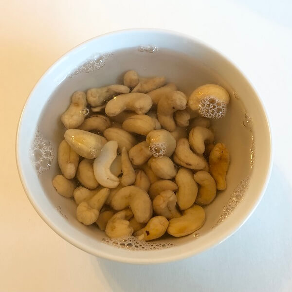 Cashews soaking in water in a bowl.