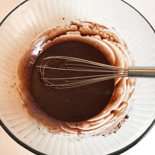 Frosting ingredients being whisked in a bowl.