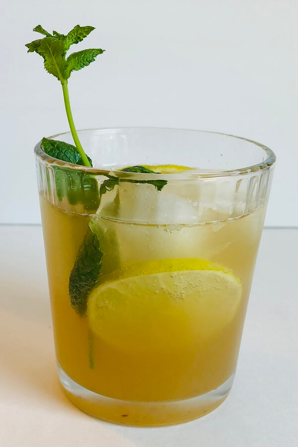 A glass of ginger ale garnished with fresh mint.