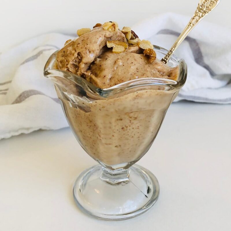 A dish of ice cream with walnuts sprinkled on top.