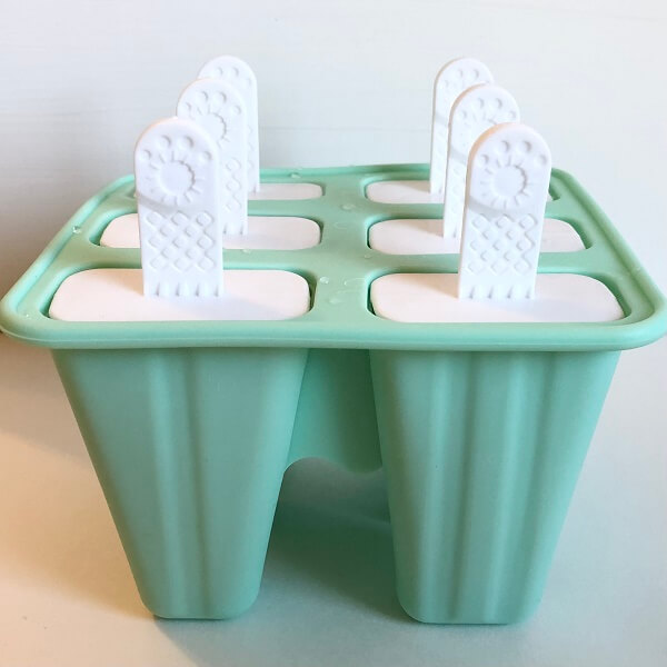 A turquoise popsicle mold with white plastic handles.