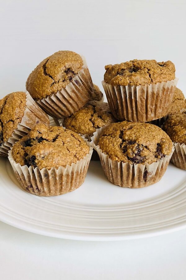 Muffins piled on a white plate.