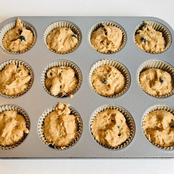 Raw blueberry muffins in a pan.