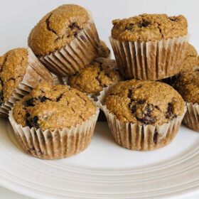 Eight muffins piled on a plate.