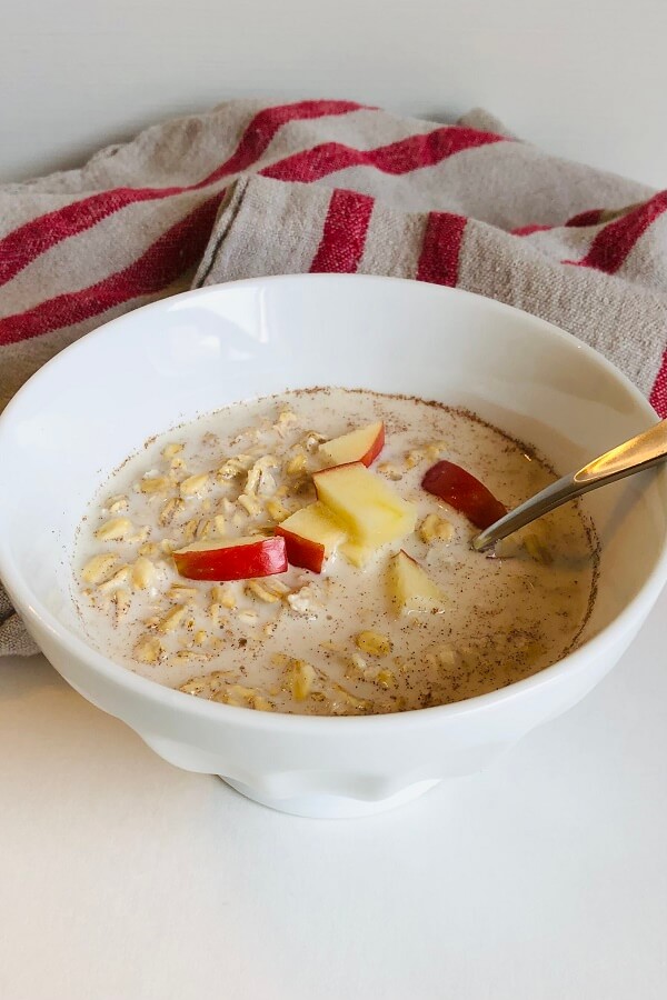 Oatmeal in a white bowl with a spoon.