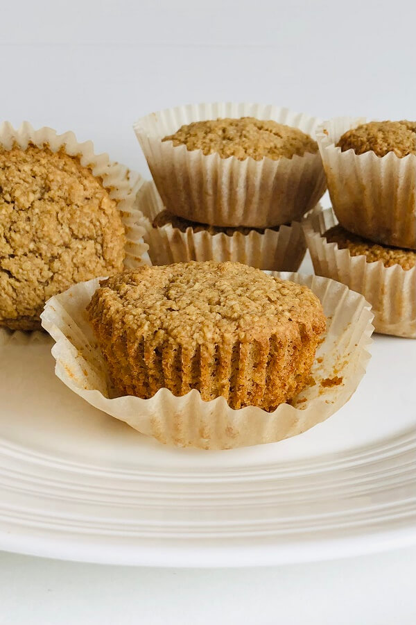 Muffins in paper baking cups arranged on a plate.