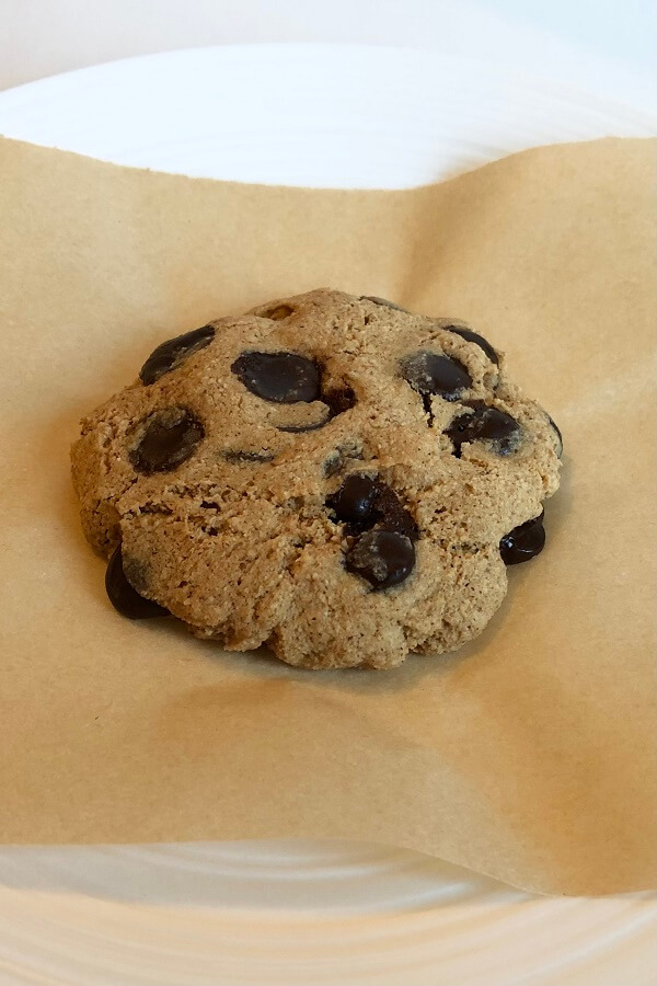 A chocolate chip cookie on parchment paper.