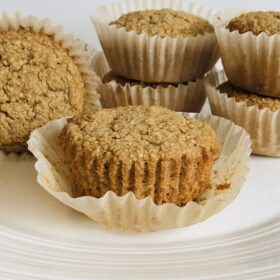 Apple sauce muffins stacked on a plate.