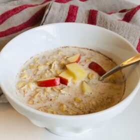 Oatmeal in a bowl next to a tea towel.