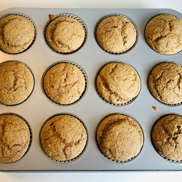 Freshly baked flax muffins in a metal pan.