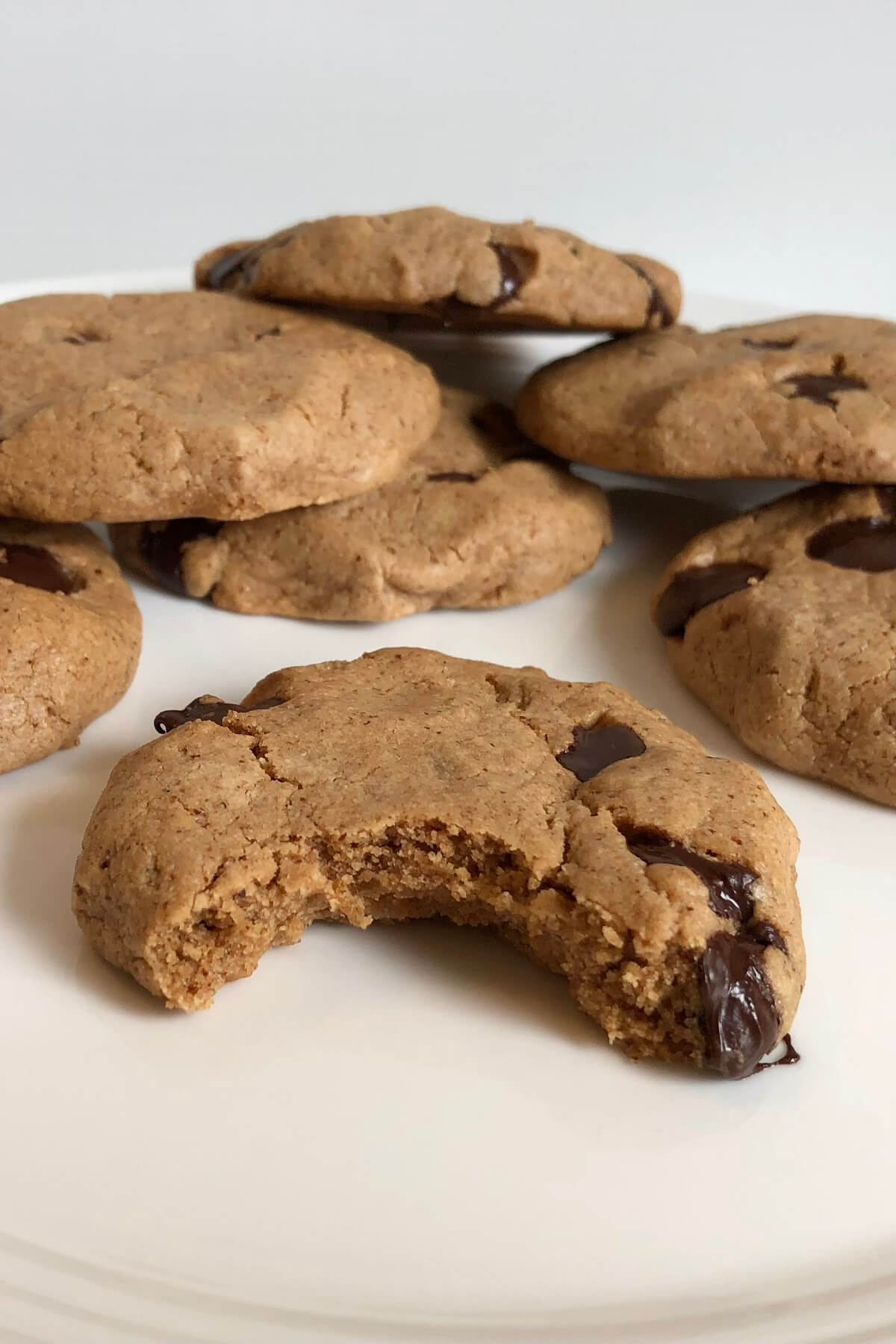 Chocolate Chip Cookies on a plate with a bite missing from one of them.