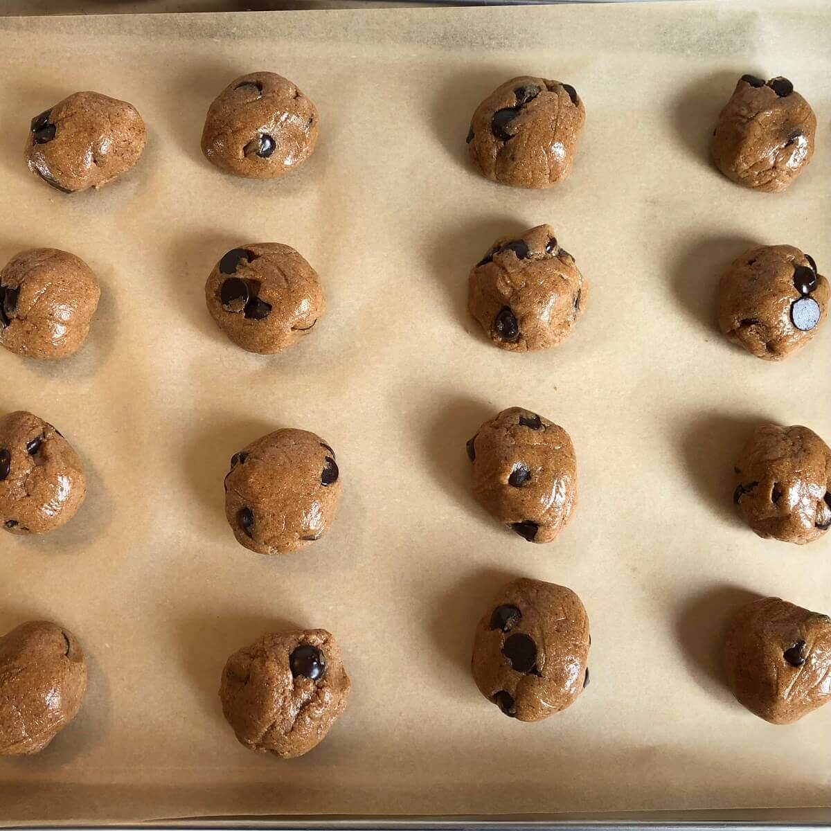 Raw cookie balls on a sheet pan.
