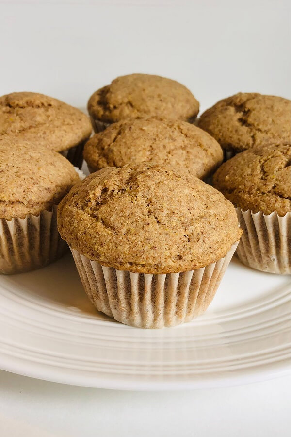 Light brown colored muffins on a white plate.