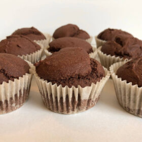 Nine chocolate whole wheat cupcakes lined up in three rows.